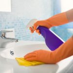 spraying-bathroom-sink-with-cleaner